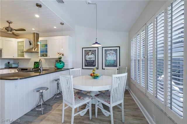 dining room featuring plenty of natural light, a ceiling fan, and wood finished floors