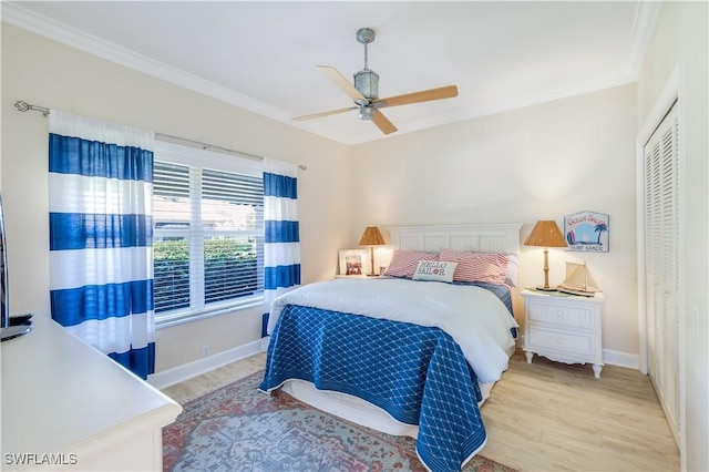 bedroom featuring baseboards, a closet, light wood-style floors, and ornamental molding