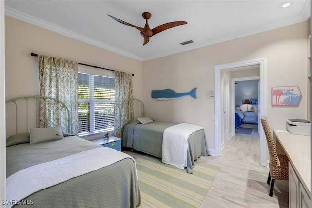 bedroom with baseboards, visible vents, light wood-style floors, a ceiling fan, and ornamental molding