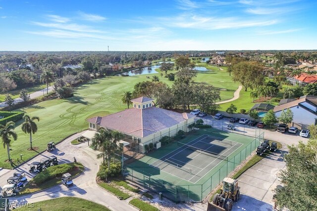 drone / aerial view featuring view of golf course, a water view, and a residential view