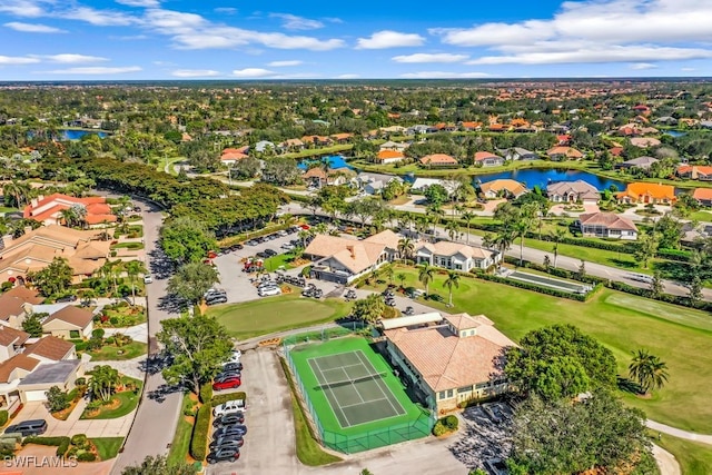 drone / aerial view featuring view of golf course, a water view, and a residential view