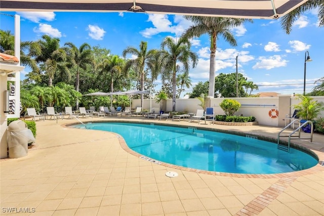 pool featuring fence and a patio area