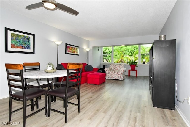 6102 Augusta Dr Unit 209, Fort Myers, FL 33907 - dining room with baseboards, a textured ceiling, a ceiling fan, and light wood-style floors