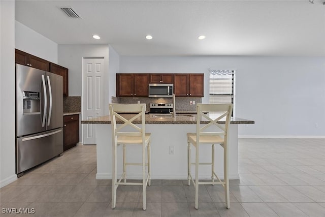 kitchen with a kitchen breakfast bar, visible vents, backsplash, and stainless steel appliances