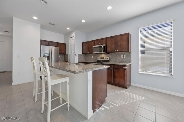 kitchen featuring a sink, stainless steel appliances, visible vents, and decorative backsplash