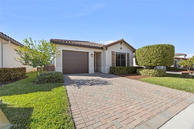 view of front of house featuring a tile roof, decorative driveway, an attached garage, and stucco siding