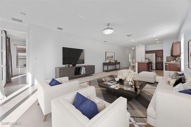 living room with light tile patterned floors, recessed lighting, visible vents, and plenty of natural light