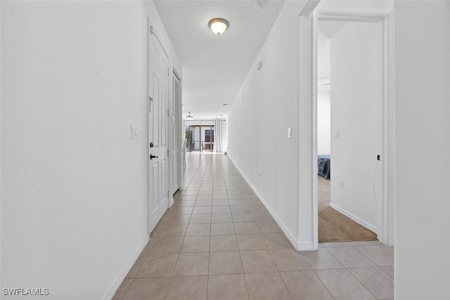 hall with light tile patterned floors and baseboards