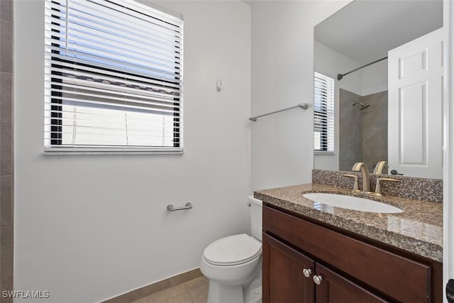 bathroom with tile patterned floors, toilet, a shower, baseboards, and vanity