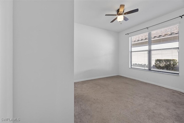 carpeted empty room featuring baseboards and ceiling fan