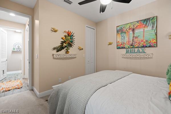 bedroom with visible vents, baseboards, carpet flooring, a closet, and a ceiling fan