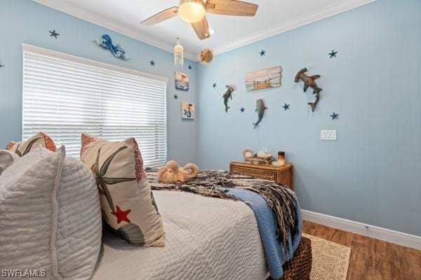 bedroom featuring ornamental molding, a ceiling fan, baseboards, and wood finished floors