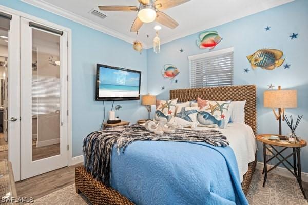 bedroom featuring visible vents, baseboards, ornamental molding, french doors, and wood finished floors