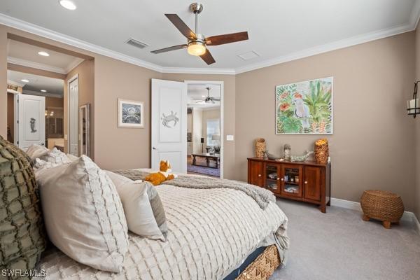 bedroom with visible vents, baseboards, light colored carpet, ornamental molding, and ensuite bathroom