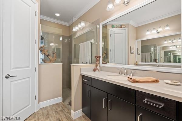 full bathroom with vanity, wood finished floors, baseboards, ornamental molding, and a walk in shower