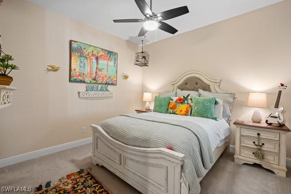 carpeted bedroom featuring baseboards and ceiling fan