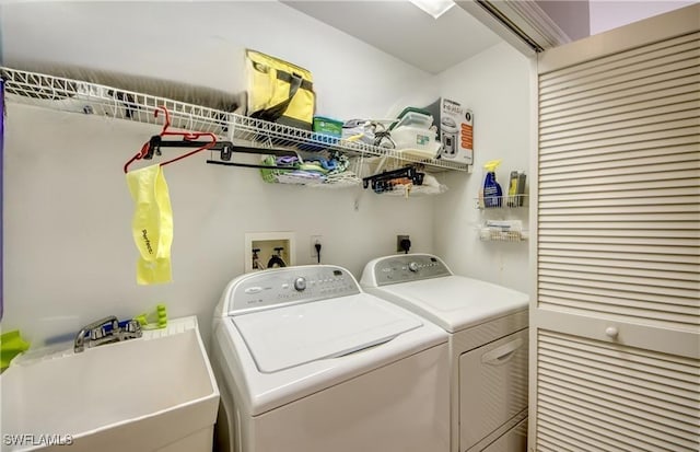 laundry area featuring laundry area, washing machine and clothes dryer, and a sink