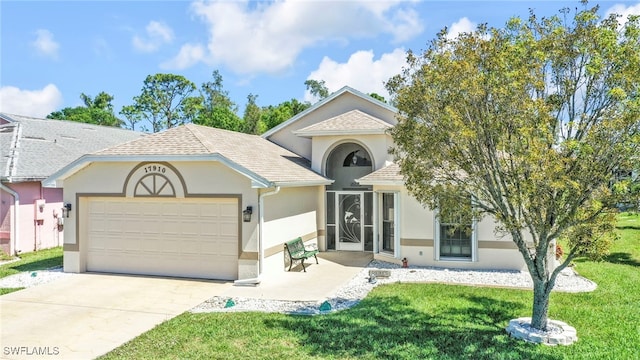 view of front of property with driveway, an attached garage, a shingled roof, stucco siding, and a front lawn