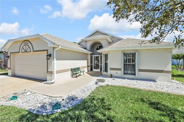 ranch-style home featuring a front yard, an attached garage, a shingled roof, stucco siding, and concrete driveway