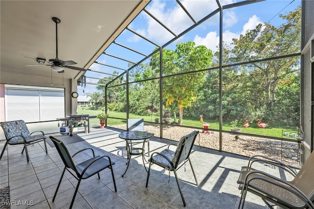 view of patio / terrace featuring glass enclosure and a ceiling fan