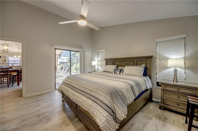 bedroom with baseboards, high vaulted ceiling, access to exterior, light wood-style floors, and ceiling fan with notable chandelier