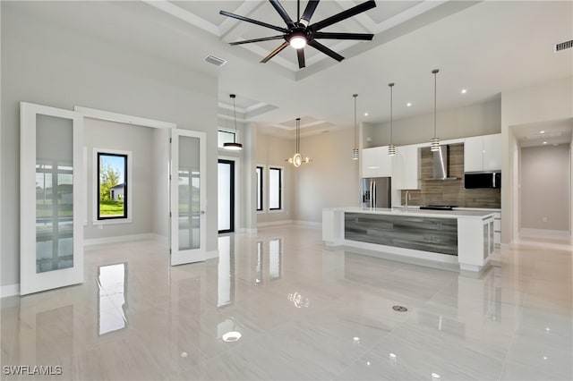 1912 SW 12th St, Cape Coral, FL 33991 - kitchen featuring light countertops, white cabinets, wall chimney range hood, modern cabinets, and stainless steel fridge