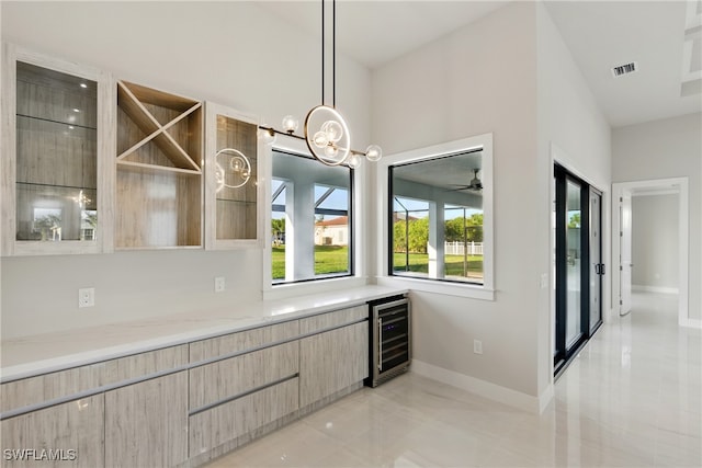 1912 SW 12th St, Cape Coral, FL 33991 - kitchen featuring visible vents, baseboards, light stone countertops, wine cooler, and modern cabinets