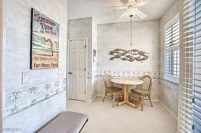 dining area featuring tile patterned floors, baseboards, and a ceiling fan