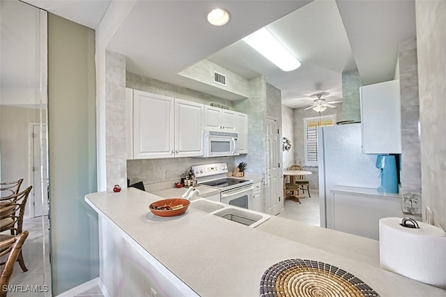 kitchen featuring white appliances, a ceiling fan, visible vents, light countertops, and white cabinetry