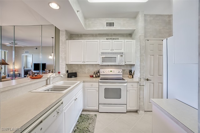 kitchen featuring white appliances, light tile patterned floors, a sink, light countertops, and white cabinetry