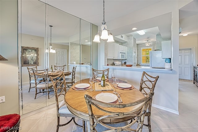 dining area with light tile patterned flooring, baseboards, and ceiling fan