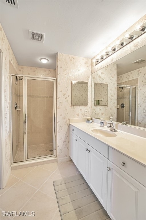 bathroom with tile patterned flooring, visible vents, wallpapered walls, a stall shower, and vanity