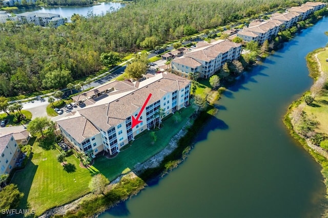 drone / aerial view featuring a forest view and a water view