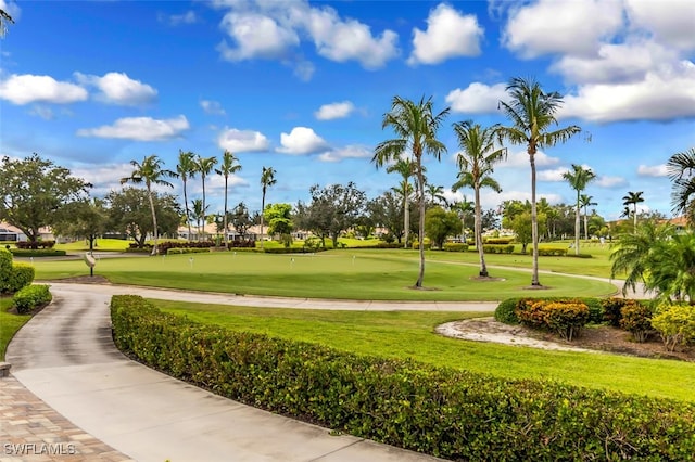 surrounding community featuring golf course view and a lawn