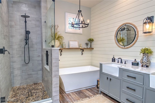 full bath featuring a shower stall, a freestanding tub, vanity, and wood finished floors