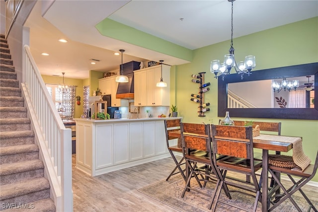 dining area featuring a notable chandelier, recessed lighting, stairway, and light wood-type flooring