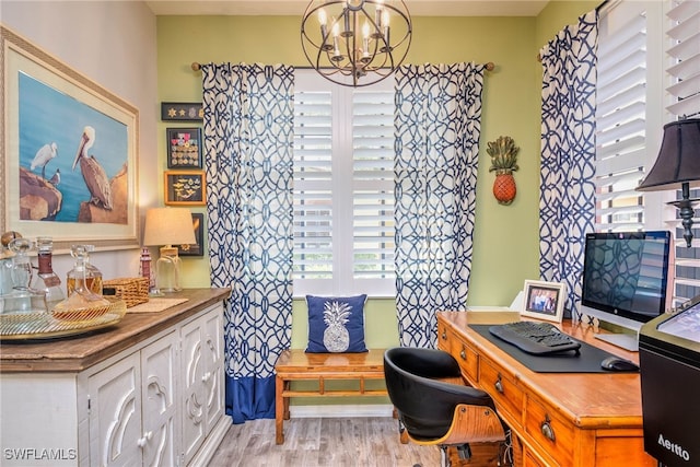 office space with light wood-type flooring, baseboards, and a chandelier