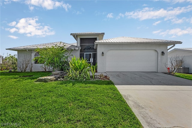 2810 Teal Ct, Saint James City, FL 33956 - view of front of home featuring driveway, an attached garage, a standing seam roof, a front lawn, and stucco siding