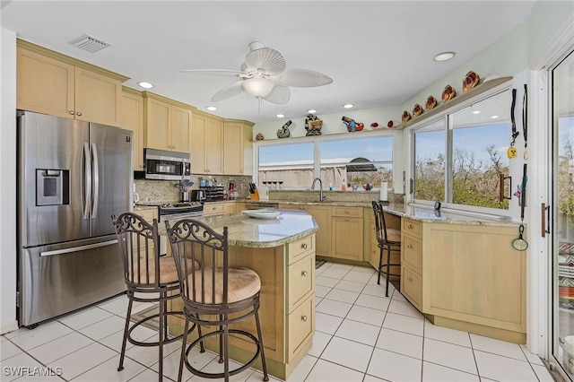 2810 Teal Ct, Saint James City, FL 33956 - kitchen featuring light tile patterned flooring, a ceiling fan, stainless steel appliances, and light brown cabinetry