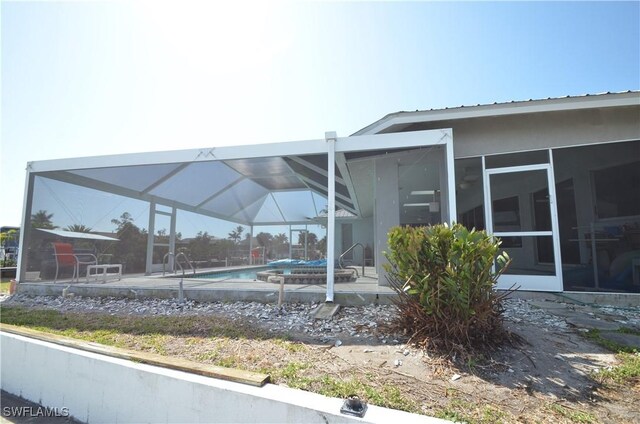2810 Teal Ct, Saint James City, FL 33956 - view of side of home featuring metal roof, a patio area, a lanai, and an outdoor pool