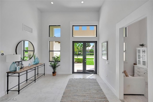 tiled foyer entrance with visible vents, recessed lighting, baseboards, and a towering ceiling