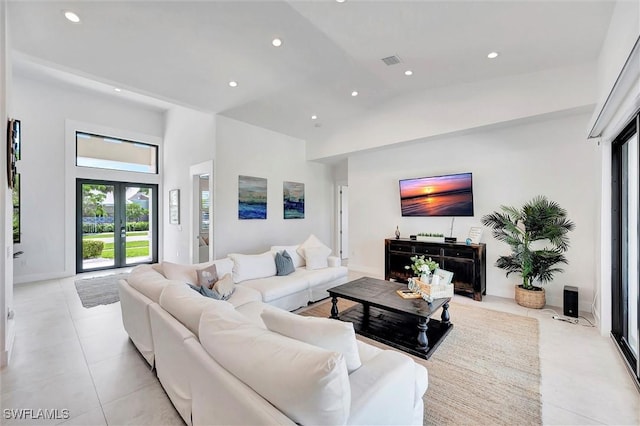 living area featuring visible vents, high vaulted ceiling, recessed lighting, light tile patterned flooring, and baseboards