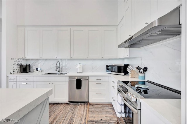 kitchen featuring a sink, stainless steel appliances, backsplash, and under cabinet range hood