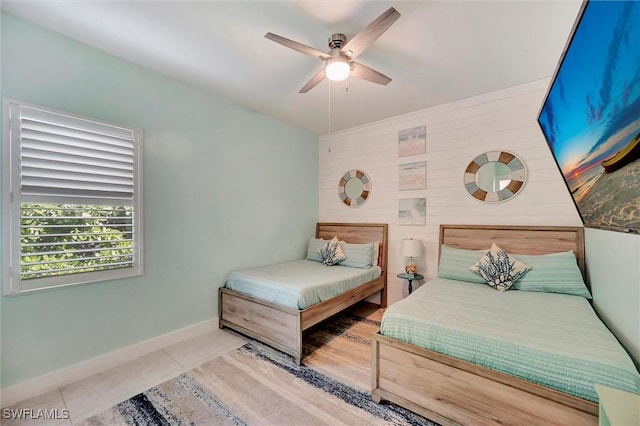 tiled bedroom with baseboards and ceiling fan