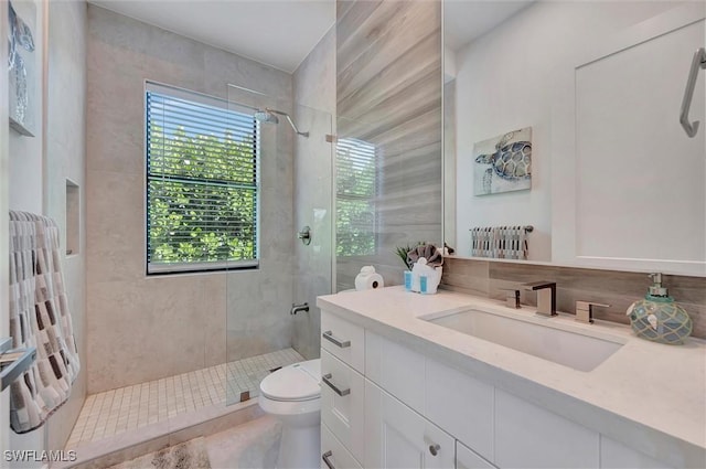 full bathroom with a stall shower, toilet, and vanity