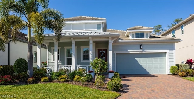 view of front of house with a garage, decorative driveway, and a porch