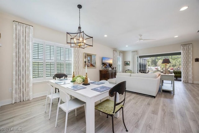 dining space with recessed lighting, ceiling fan with notable chandelier, light wood-type flooring, and baseboards