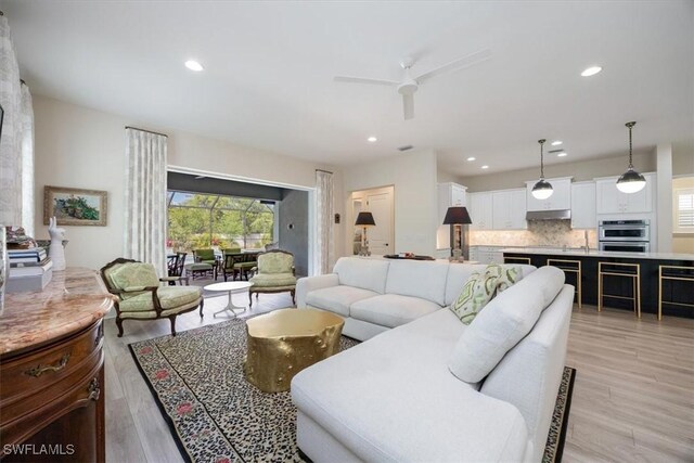 living room with recessed lighting, light wood-style flooring, and a ceiling fan