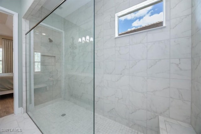 bathroom with marble finish floor, ensuite bathroom, and walk in shower