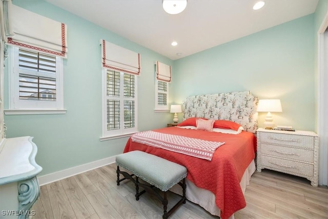 bedroom with recessed lighting, multiple windows, baseboards, and wood finished floors